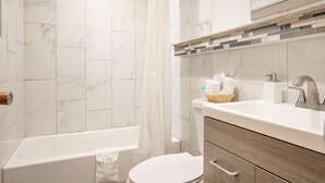 Ein modernes Badezimmer mit Badewanne, Toilette und Waschbecken.