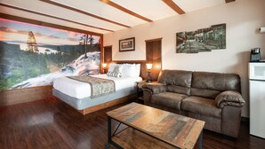 Ein Schlafzimmer mit einem Bett, einem Schlafsofa, einem Couchtisch und einem Bild eines Wasserfalls.