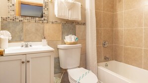 A bathroom with a toilet, sink, and bathtub. - Salt Water Lagoon - Queen Studio Room at Wanderlust Inn, Pet Friendly (Ocean Shores)