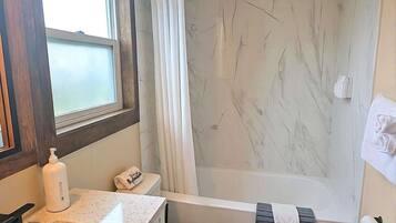 Tina con regadera, secadora de cabello, toallas