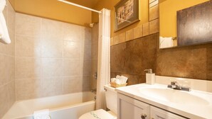 A bathroom with a bathtub, toilet, and sink. - Ocean Song - Queen Studio Room at Wanderlust Inn, Pet Friendly (Ocean shores)
