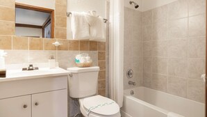 A bathroom with a toilet, sink, and bathtub. - Once Upon a Tide - Queen Studio Room at Wanderlust Inn, Pet Friendly (Ocean shores)