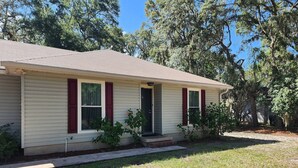 A single-story house with a gabled roof, a front porch, and a small front yard.