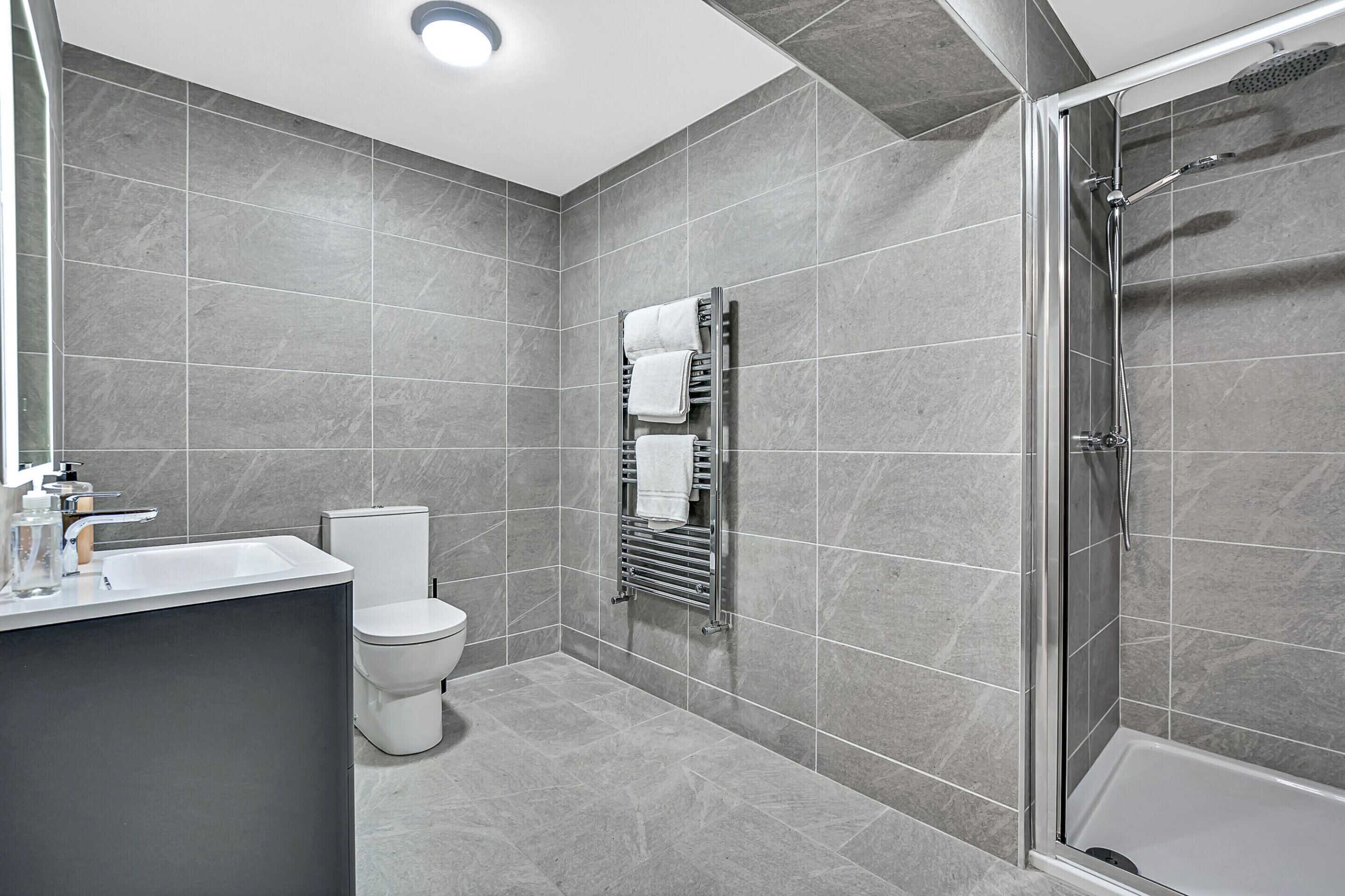 Een douche, handdoeken, zeep, toiletpapier