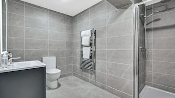 Een douche, handdoeken, zeep, toiletpapier