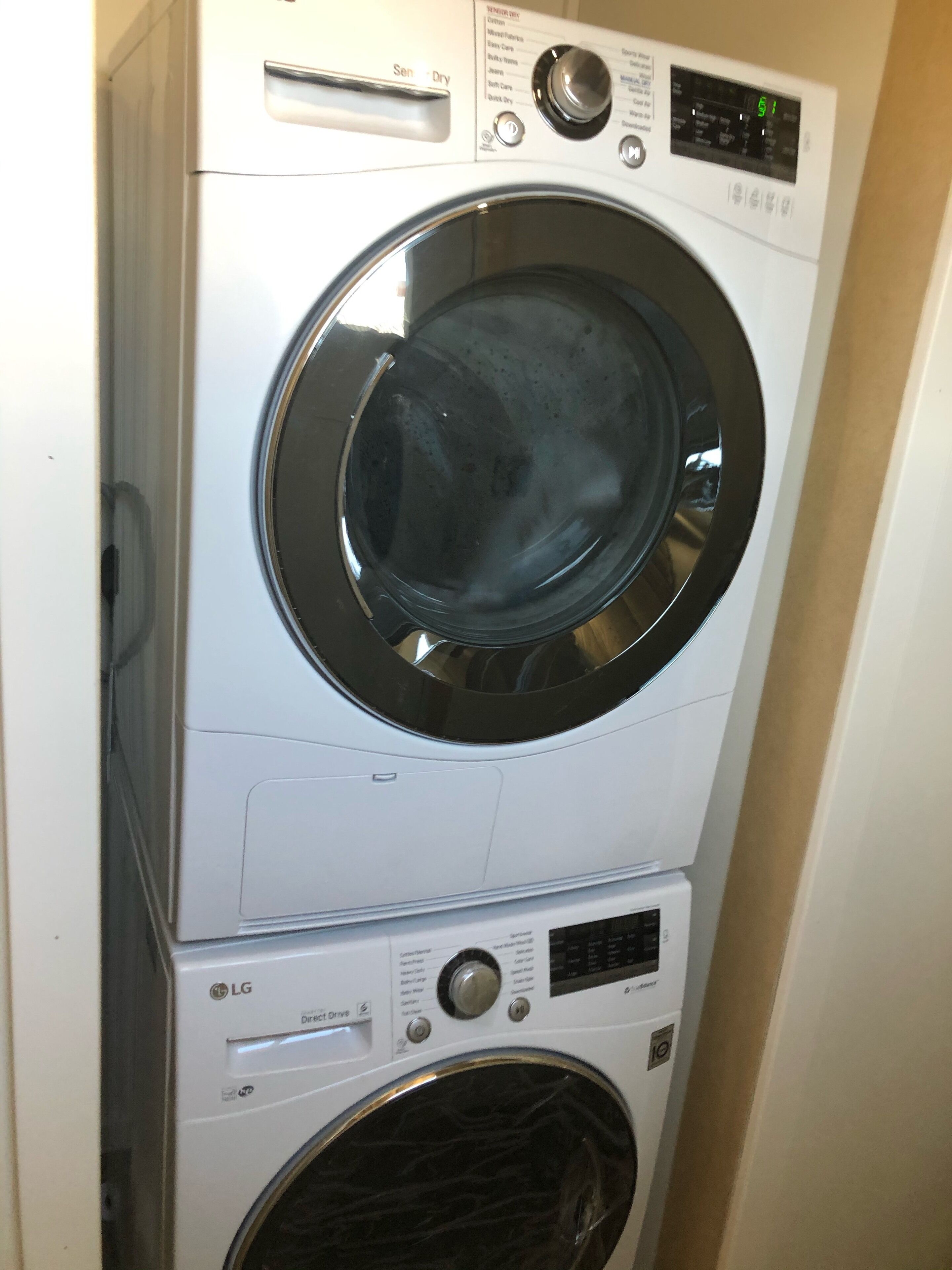 A stacked washer and dryer unit with a control panel and a digital display.
