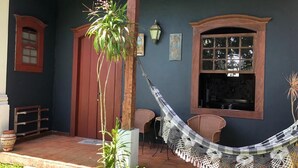 Una habitación con una hamaca, una ventana y una puerta.