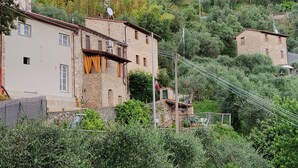 Un pueblo en una ladera con edificios de piedra, algunos con antenas parabólicas.