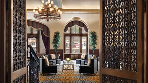 A lobby with a chandelier, two sofas, a coffee table, and a patterned carpet. - Fairmont Banff Springs Gold Experience (Banff)