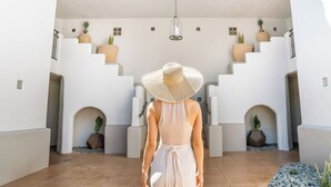 A person walking up a white staircase in a modern building with potted plants and a hanging light fixture. - Privado Villas at the Fairmont Scottsdale Princess (Scottsdale)