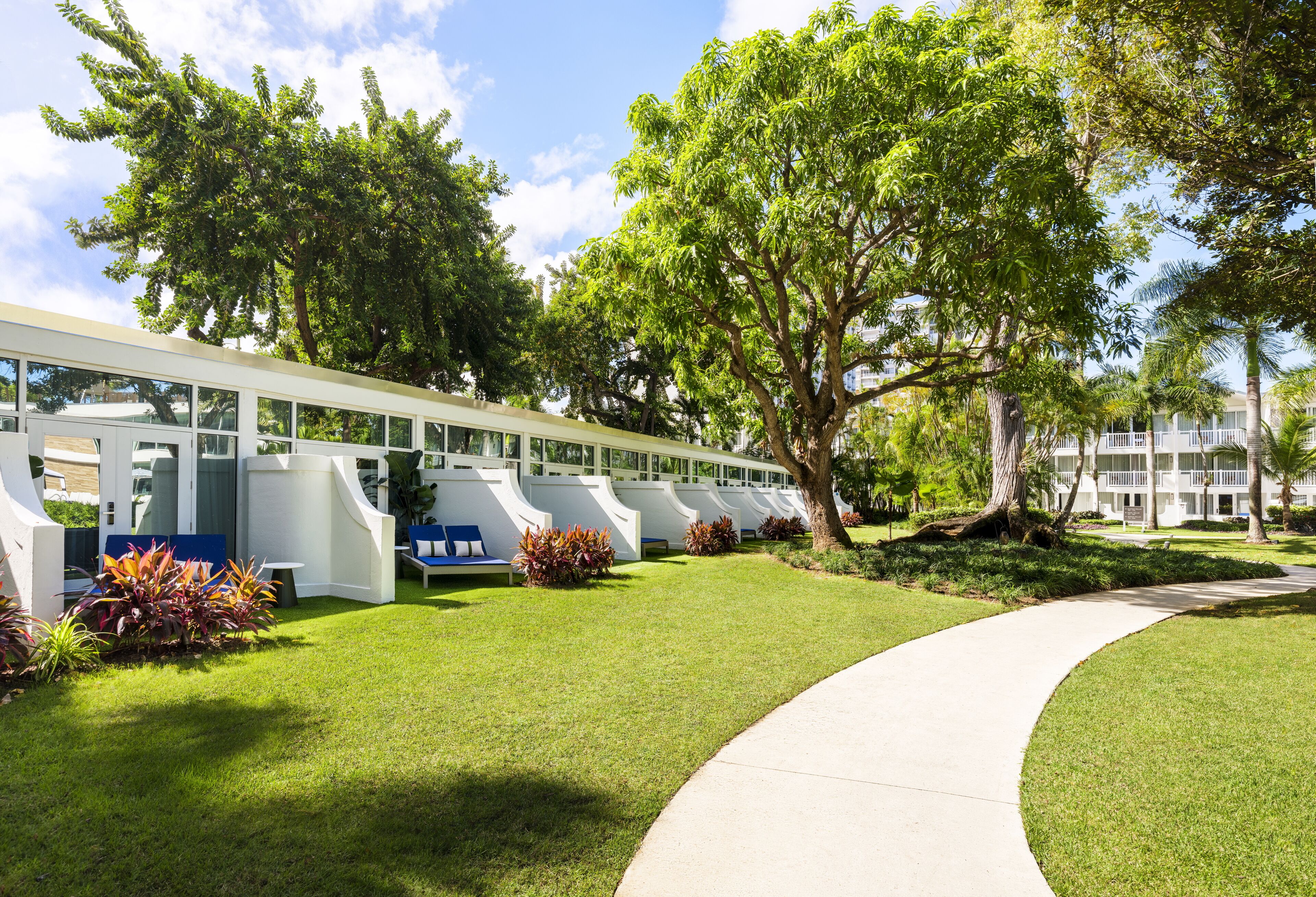 A modern building with a curved pathway and seating areas.