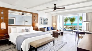 A modern hotel room with a large bed, a desk, and a balcony with a view of the ocean. - Fairmont El San Juan Villa Experience (Carolina)
