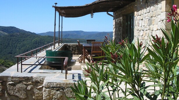 A stone building with a balcony overlooking a mountainous landscape. - Gite 6 people in a stone farmhouse, swimming pool, property 10Ha, panoramic view (Rocles)