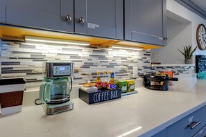Una cocina moderna con un mostrador de café, una cafetera y diversos productos de café.
