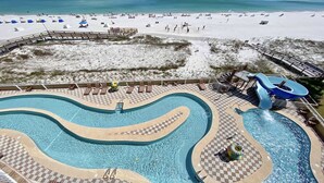 Un complexe hôtelier doté d’une grande piscine, d’une plage et d’un toboggan aquatique.