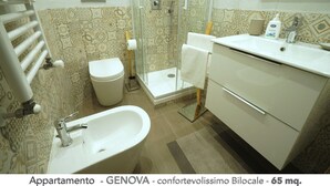 Une salle de bain équipée d’une douche, de toilettes, d’un lavabo et d’une douche à l’italienne.