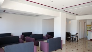 A modern waiting area with multiple seating options, a dining table, and a clean, tiled floor. - Stunning 2-bed Apartment in Sarandë (Sarandë)