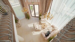 A spacious living area with a sofa set, a coffee table, and decorative plants.