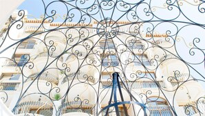 A building with ornate wrought iron balconies and a central spiral staircase.