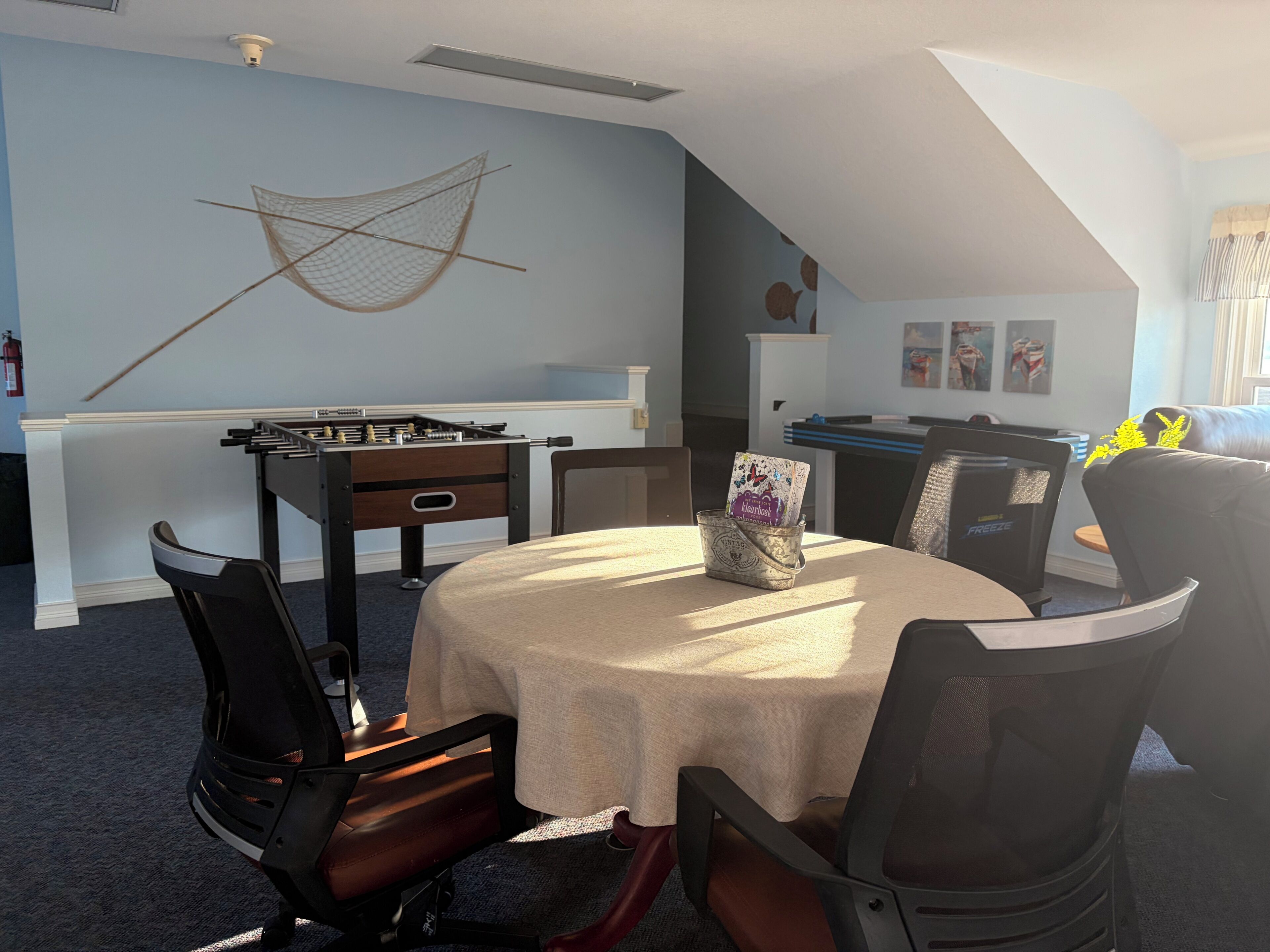 A dining area with a table, chairs, and a foosball table.