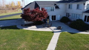 A two-story house with a covered patio, a lawn, and a driveway.