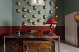 Una habitación con una mesa, un paraguas rojo y varias linternas colgantes.