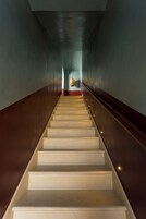 Una escalera con barandilla y una lámpara colgante en la parte superior.