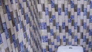 Une salle de bain avec un mur carrelé et des toilettes.