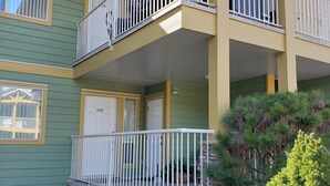 A multi-story building with balconies, a welcome mat, and potted plants. - Quiet condo at beautiful Mabel Lake (Enderby)