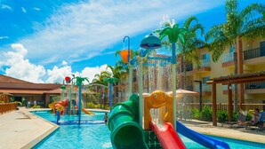 A water park with multiple slides and water features, surrounded by palm trees and a pool. - Ondas Praia Resort by WAM Experience  (Porto Seguro)