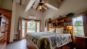 A bedroom with a bed, a bookshelf, a ceiling fan, and a window with curtains. - El Gran Castillo de Arena (San Pedro)