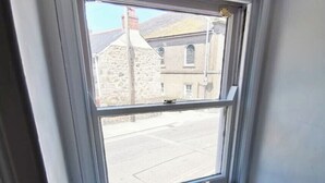 Una ventana con vistas a una calle y edificios.