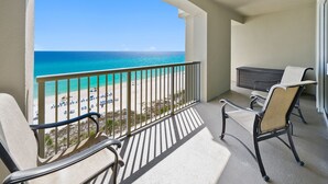 A balcony with a view of a beach and ocean. There are two chairs and a small table. - Grand Panama 904 Gulf Front & Pet Friendly, Sleeps 9 (Panama City Beach)