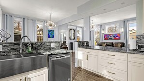A modern kitchen with white cabinets, a stainless steel sink, and a built-in dishwasher. - Downtown Breck~7BR&7BA~Walk to Gondola~Hot Tub~AC~3 Parking Spots (Breckenridge)