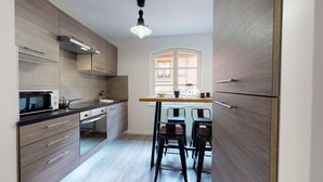 Cozinha moderna com micro-ondas, fogão e banquetas de bar.
