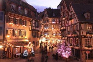 Eine typische europäische Straße mit Fachwerkhäusern, einem Weihnachtsmarkt und einem geschmückten Weihnachtsbaum.
