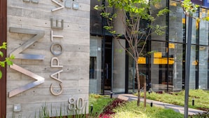 A modern building facade with a wooden panel design and large metal letters spelling "ZAPAD". - Charlie Oscar Freire (São Paulo)