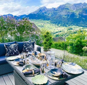 Una mesa de comedor al aire libre con una vista panorámica de las montañas.