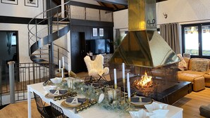 Ein modernes Wohnzimmer mit Kamin, einer Wendeltreppe und einer gemütlichen Sitzecke.