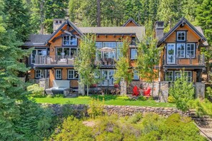 A multi-story lodge with a stone foundation, wooden exterior, and multiple balconies.