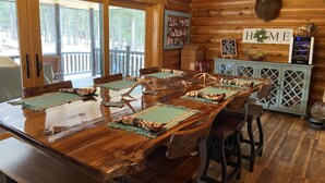 A wooden dining table with benches, a mounted bear head, and a 'HOME' sign.