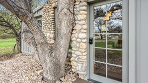 A stone building with a large tree in front, a door with a window, and a sign that reads "WATERHOUSE ROOM." - The Walnut Tree Room at River Stone Inn at Bryce (Tropic)