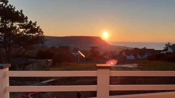 A sunset view from a balcony with a railing, overlooking a residential area with houses and a road. - Ravissant ! Le Panorama - Vue Mer (Criel-sur-Mer)