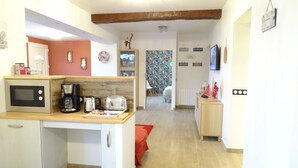 A compact kitchen with a microwave, coffee maker, toaster, and a small cabinet. A red cushion is visible on the floor. - Ravissant ! Le Panorama - Vue Mer (Criel-sur-Mer)