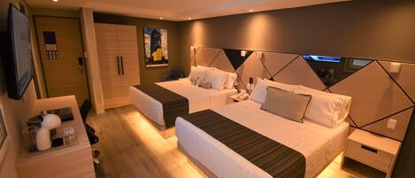 A modern hotel room with two beds, a desk, and a wardrobe.
