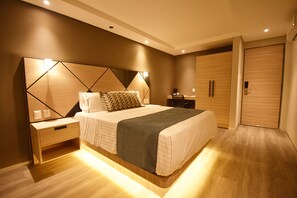 A modern bedroom with a large bed, bedside tables, a wardrobe, and a nightstand. - KALI Centro Mexico City (Mexico City)