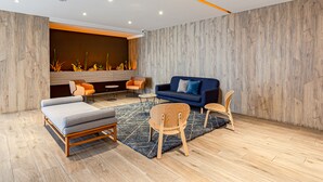 Ein modernes Wohnzimmer mit einer Couch, Sesseln und einem Couchtisch.
