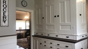 Una cocina con armarios blancos, un reloj y un letrero que dice 'Grocery'.
