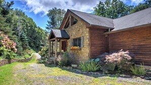 A stone and wood cabin with a stone foundation, a wooden extension, and a stone chimney.
