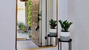 A hallway with a large mirror reflecting a door and a small potted plant. - Completely Remodeled, Full Tennis Privileges, ALWAYS Clean at Palm Valley CC!!   (Palm Desert)